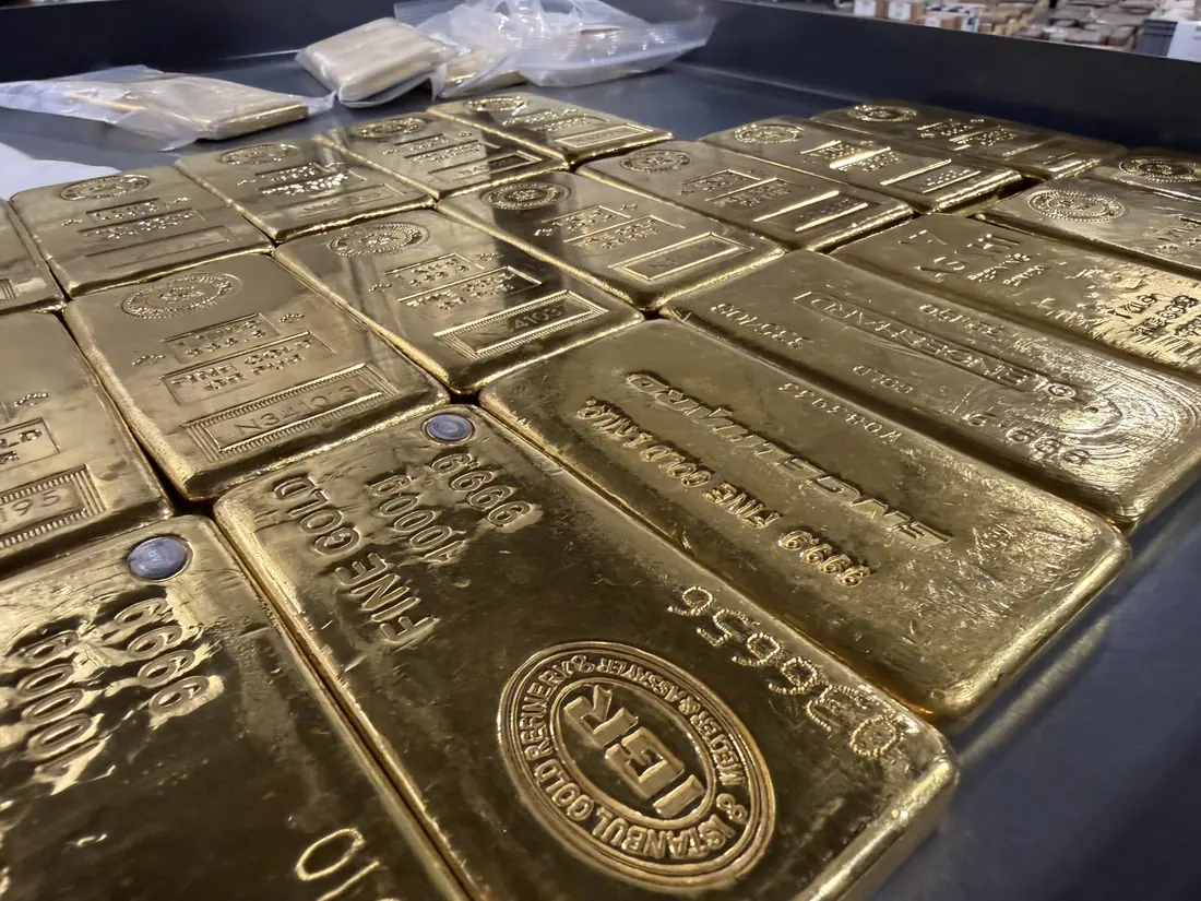 Stamped one-kilogram fine gold bars laid out in rows on a vault table.