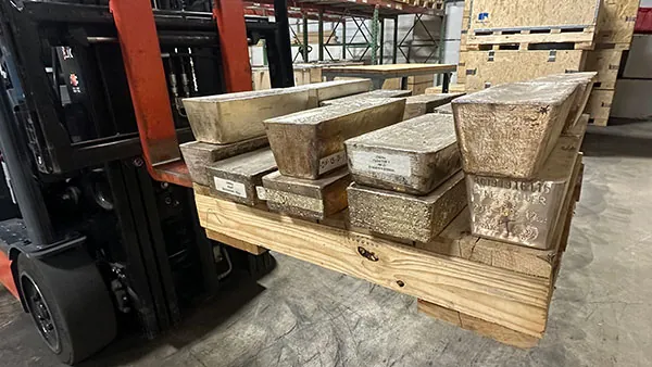 Forklift moving a pallet of 1,000 oz silver bars in a bullion depository