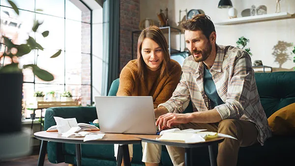 Couple reviewing their precious metals IRA on a laptop at home