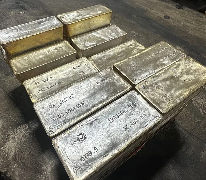 Large silver bullion bars stamped with serial numbers, weights in kilograms, and 999.9 fineness, stacked on a depository floor